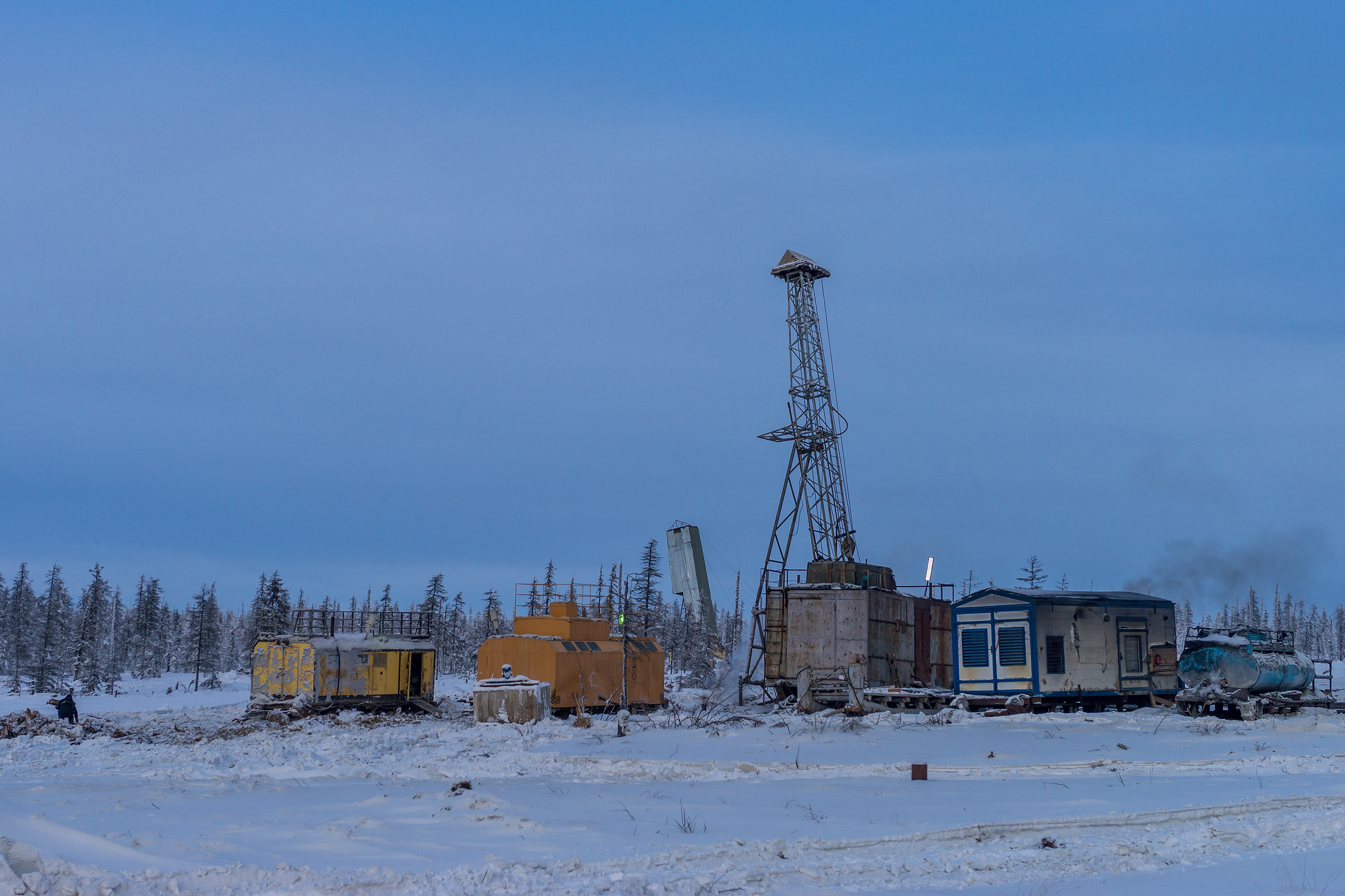Rig and structures in Winter forest. Season work. Snow and ice road.